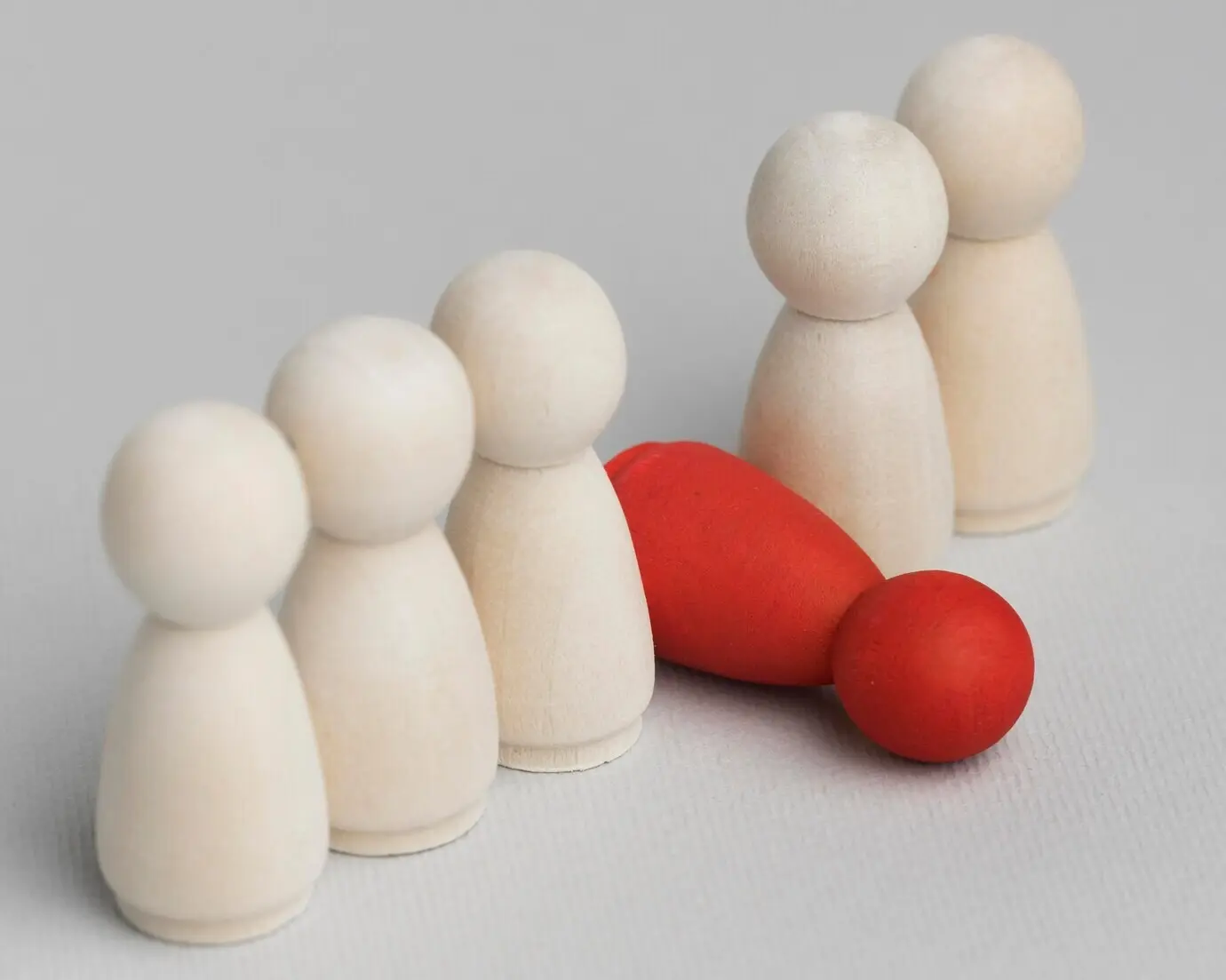A fallen red pawn next to an assortment of white ones.