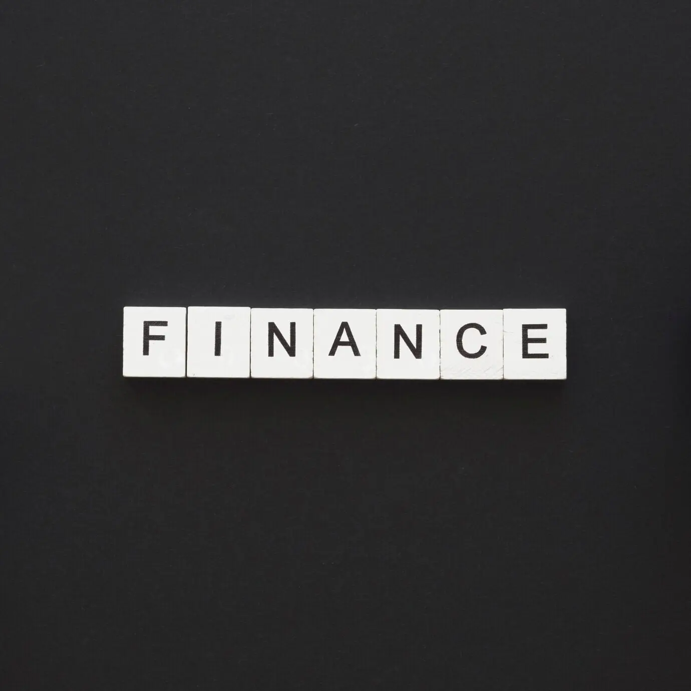 The word “Finance” written on wooden cubes.